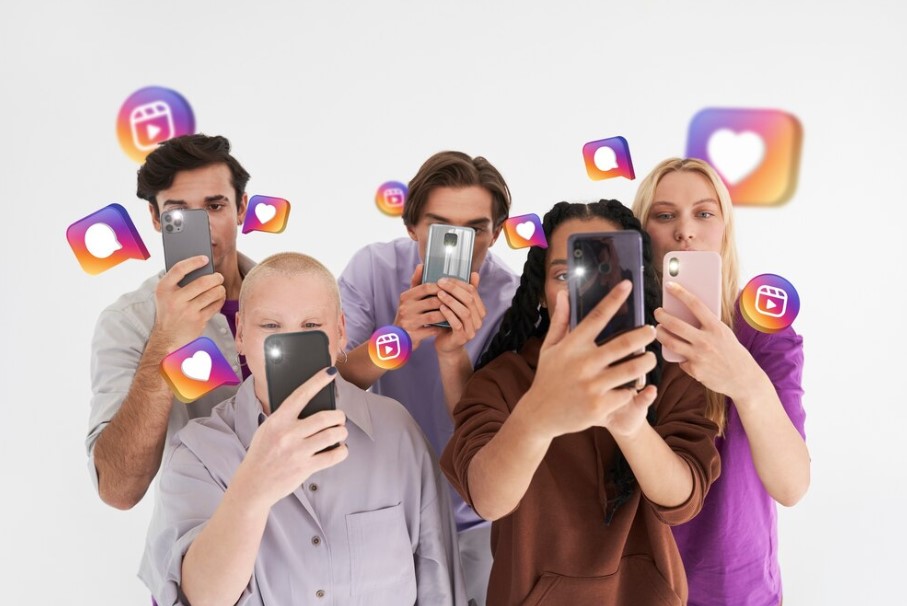 Grupo de jovens usando smartphones com ícones de mídias sociais flutuando.
