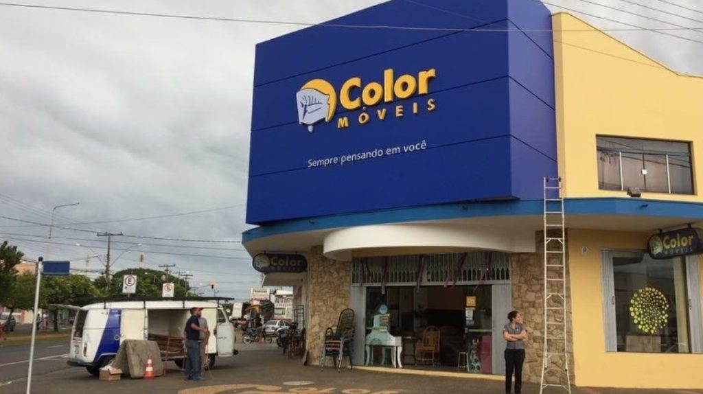 achada da loja Color Móveis com letreiro azul e logotipo de cadeira.