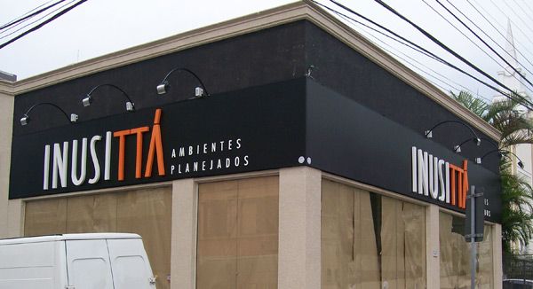Fachada da loja INUSITTÁ AMBIENTES PLANEJADOS em Ribeirão das Neves, com letreiro preto e laranja.