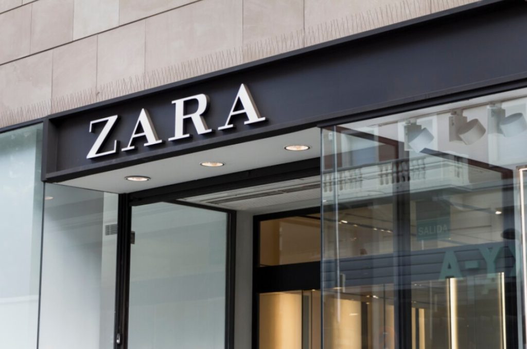 Fachada da loja Zara com letreiro branco em fundo preto.