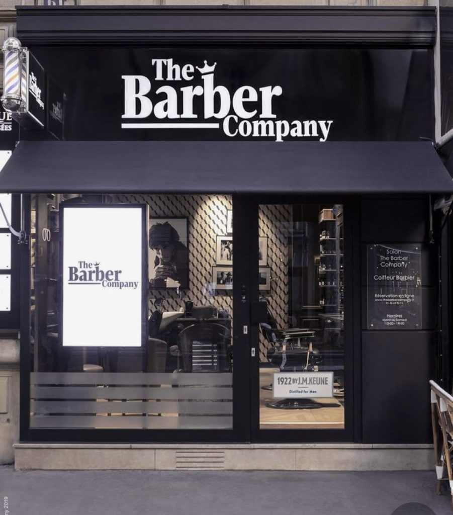 Fachada da The Barber Company com design moderno e interior visível.