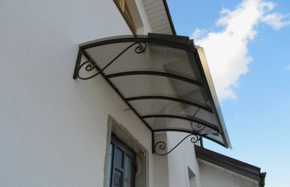 oldo transparente fixo acima da porta com estrutura metálica decorativa.