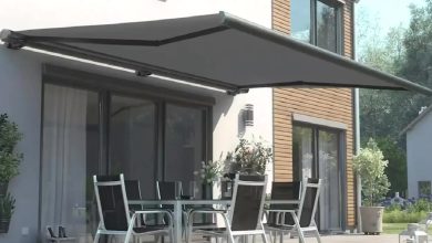 Casa moderna com pátio, toldo retrátil, elegante mesa e cadeiras.