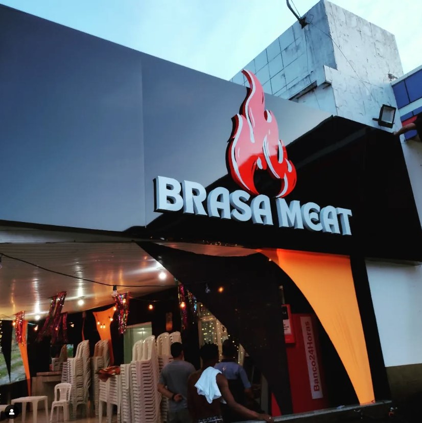 Fachada em construção da "conexão FOOD HALL" com letras iluminadas.