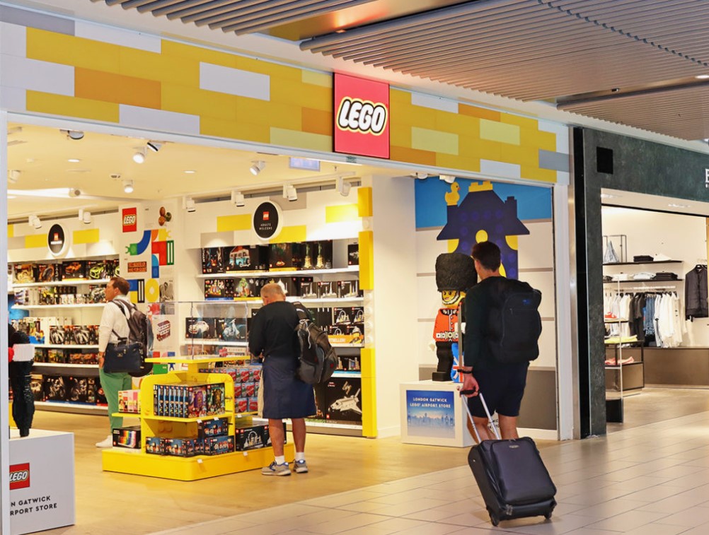 Fachada da loja LEGO vibrante, colorida com logo icônico visível.