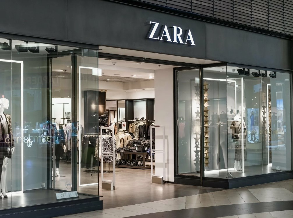 Fachada da loja Zara com design moderno e iluminado.
