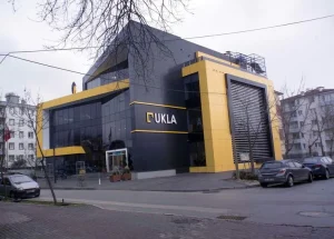 Edifício moderno "UKLA" com janelas amplas e cores marcantes.