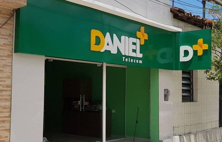 Fachada da "Daniel Telecom" com placa verde e amarelo vibrante.