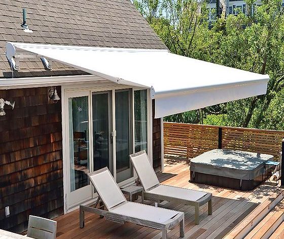 Toldo retrátil cor banca instalado sobre fachada de casa moderna aconchegante.