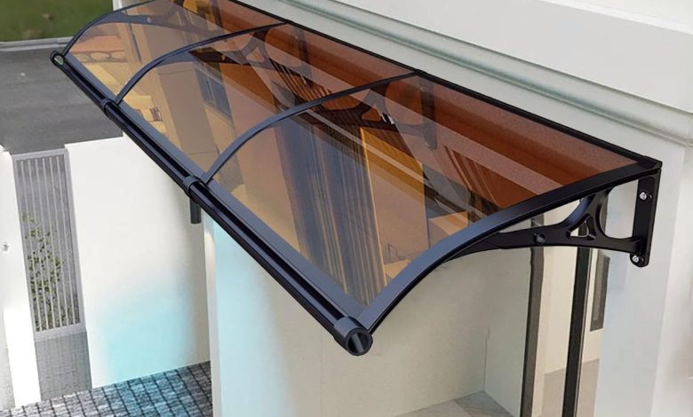 Toldo fixo de policarbonato fumê sustentado por estrutura metálica preta.