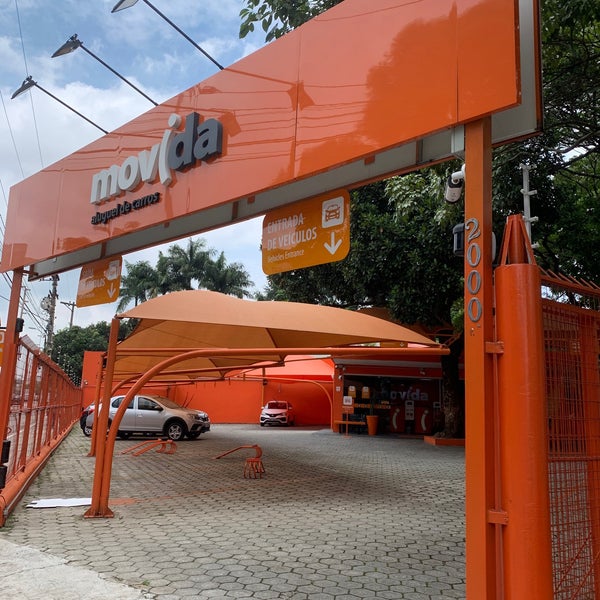 Fachada da "movida rent a car" com design moderno.