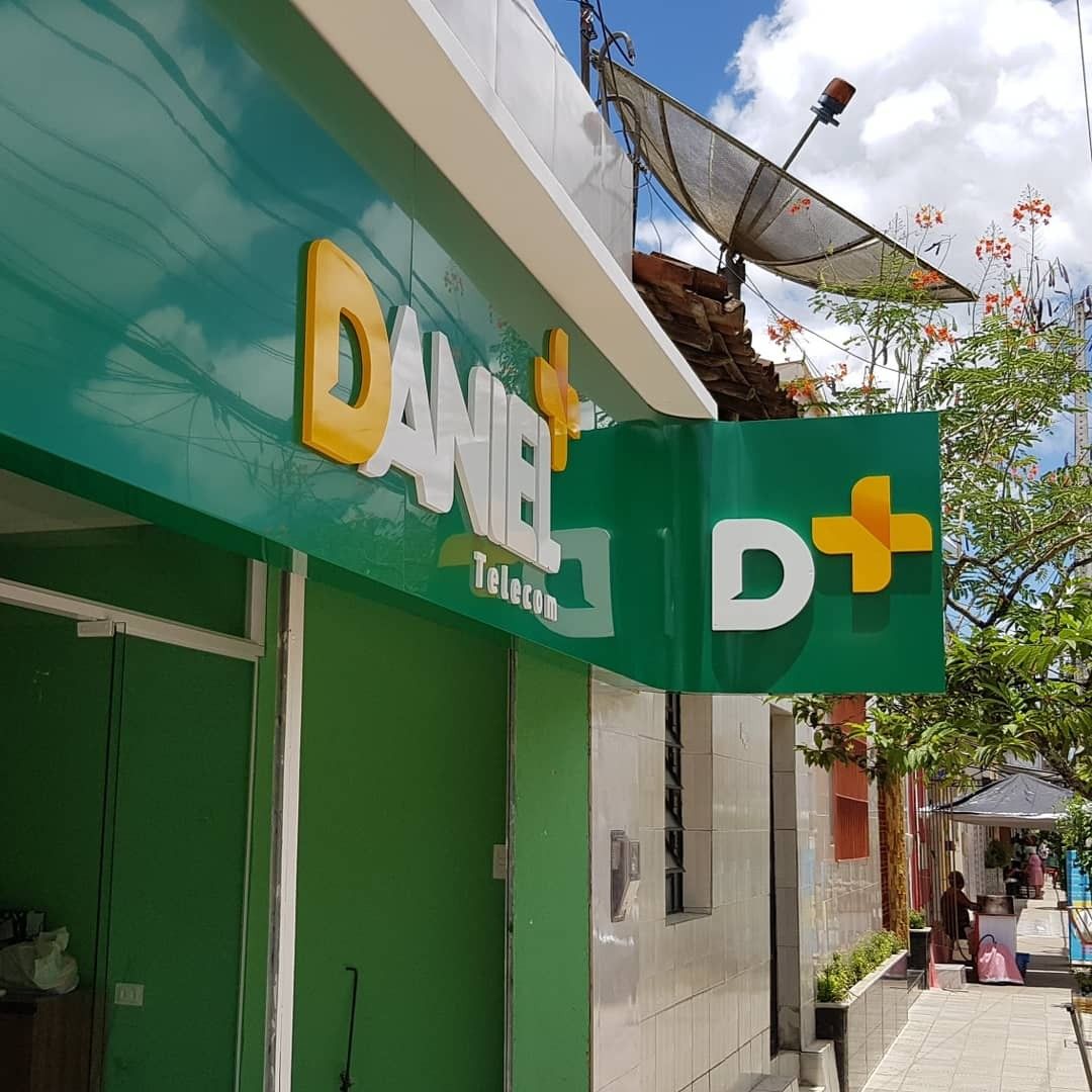 Fachada da "DANIEL Telecom" com design vibrante em verde e amarelo.