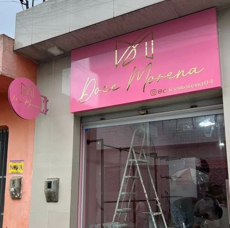 Placa rosa “Doce Morena” com logo dourado e Instagram visível.