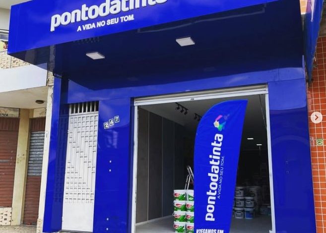 Fachada azul vibrante da loja Pontodatinta com banner promocional.