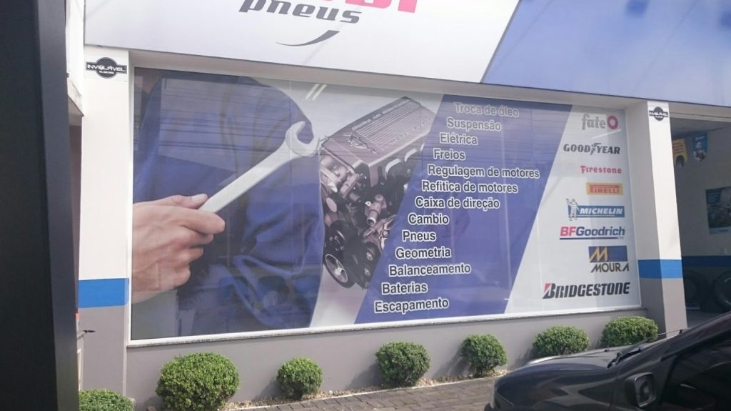 Adesivo Perfurado automotivo exibe serviços mecânicos com marcas e visual profissional.