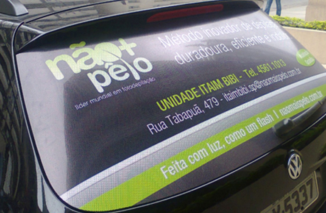 Carro com adesivo perfurado divulga serviço de fotodepilação profissional.