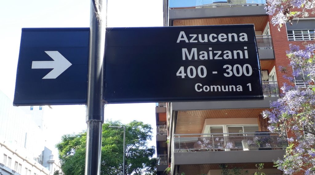 Placa azul urbana indica rua Azucena Maizani e numeração local.